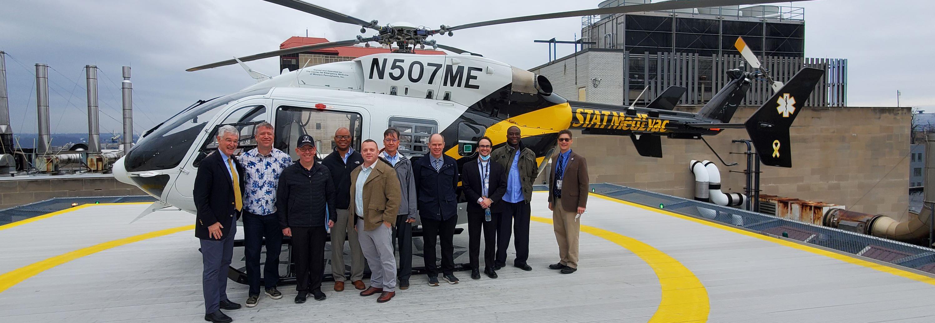 Group of people in front of a helicopter