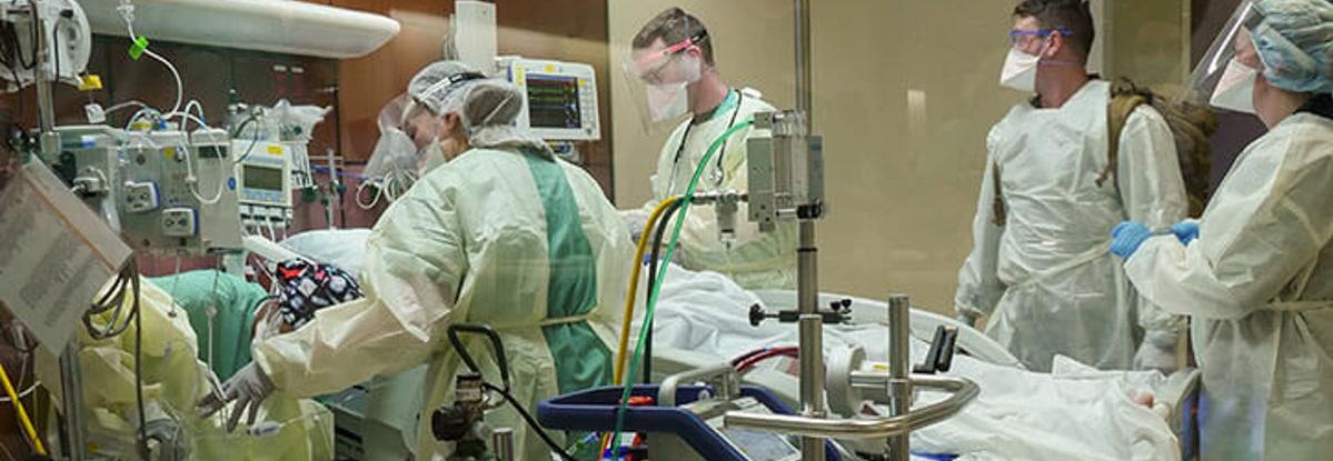 Operating room image. Four medical professionals fully gowned.
