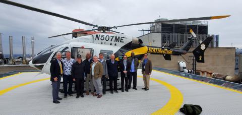 Group of people standing in front of a helicopter